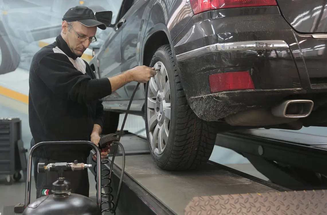 Image of a mechanic checking the tire pressure in a tire shop for sale in Canada