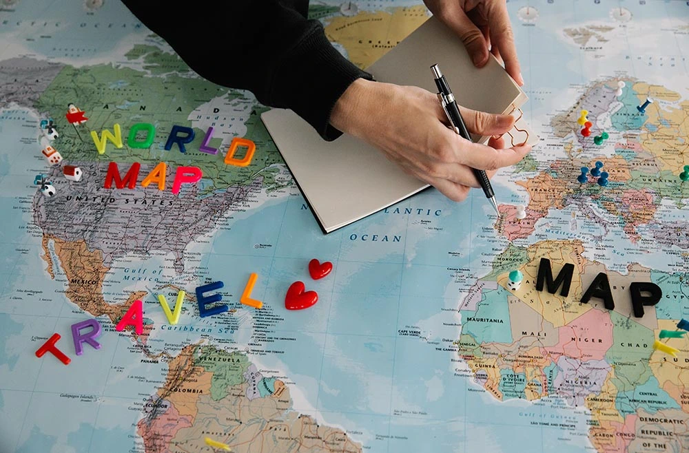 Image of a world map and an agent planning a travel itinerary at a travel agency for sale in Canada